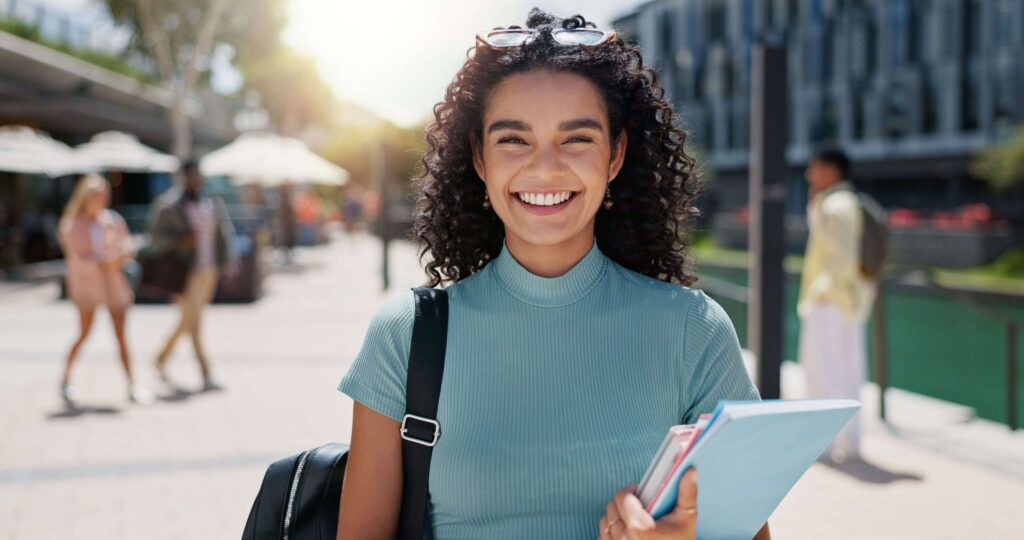 young woman outdoors with school books and backpack